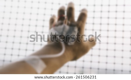 Depressing hand of patient on mesh focusing on fingertips with vintage effect