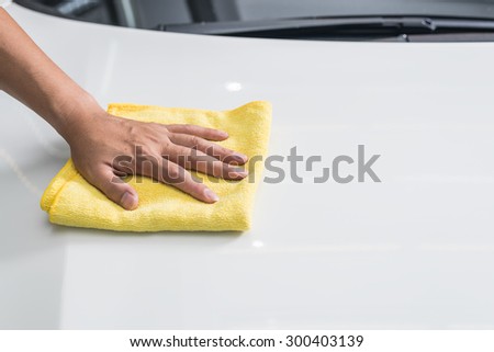Car polishing series : Hand of worker using yellow towel wiping white car hood