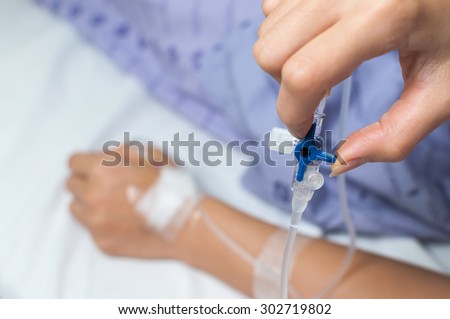 Patient\'s hand adjust iv hose by herself