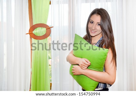 Cute girl holding a green pillow
