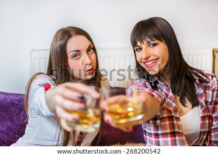Pretty women having a drink together at home.