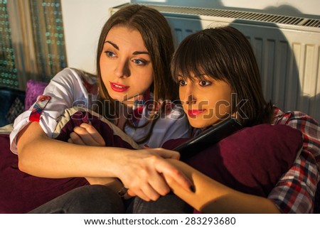 Two female friends watching scary movie.