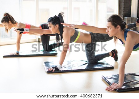 Group women stretching training exercising in gym practicing yoga pilates.