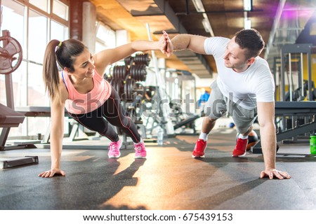 Young sporty couple working out together at gym.