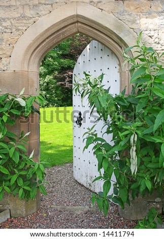 Secret Garden, sunlight lies beyond ancient garden wall and Arched Door