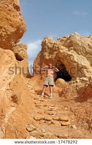 Modern Day Caveman emerges from Cave and stretches with a yawn. Taken in the Atlas Mountains of North Africa