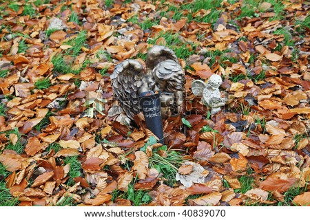 In Loving Memory, Two Angles mark a Grave amongst Autumn leaves