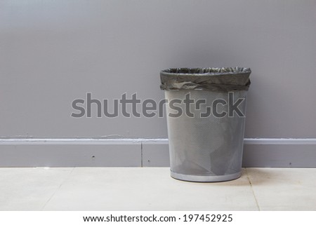 An empty metal trashcan (bin) isolated on gray background