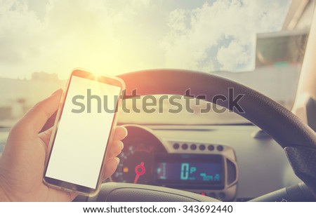 Using cellphone in car - with defocused city traffic.