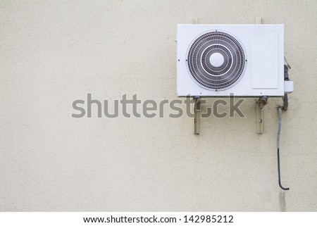 Old air conditioner mounted outside on a grey wall