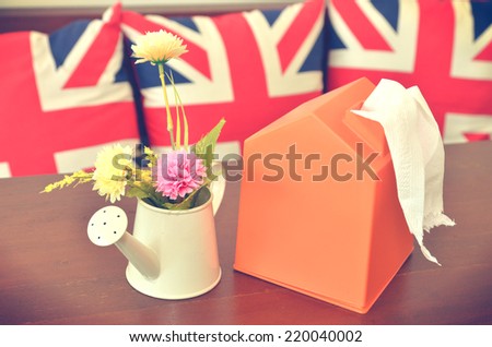 flower in vase and tissue box on table