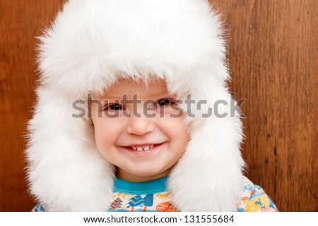 closeup portrait of little girl in big white winter hat big smile