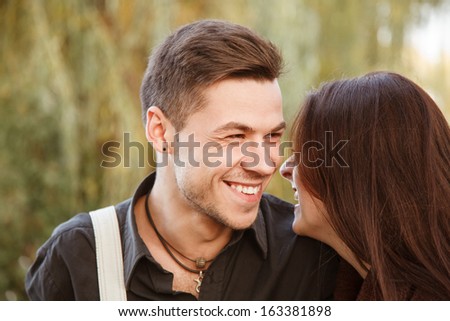 young couple walking in park laughing close-up