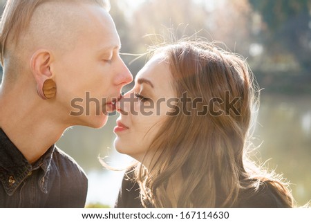 young male kissing females nose with eyes closed