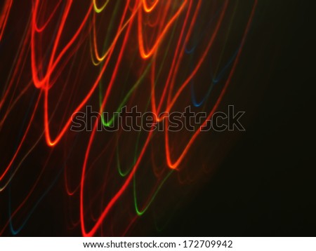 Abstract colorful light streaks texture with dark background.
