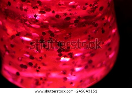 Pink lava lamp with bright stars in the dark, close up.