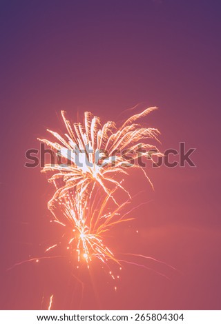 Photo of fireworks in purple and orange colour background.