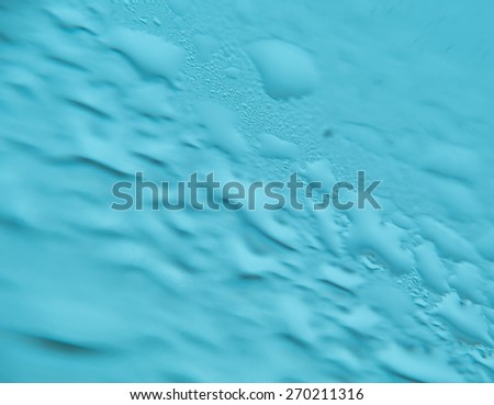 Extremely close up of wet surface, blue toning background.