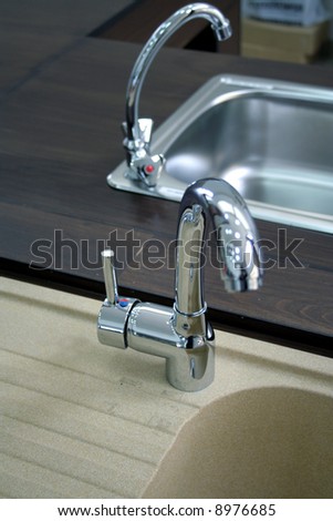 Two kitchen faucets with stainless steel sink