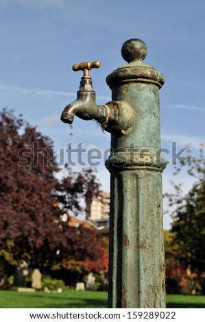 Rusted public water tap with drips