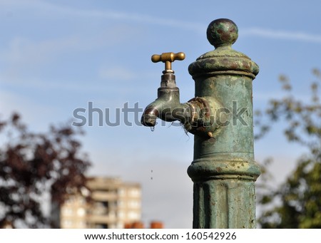 Old rusted and broken public water tap in London cemetery, UK