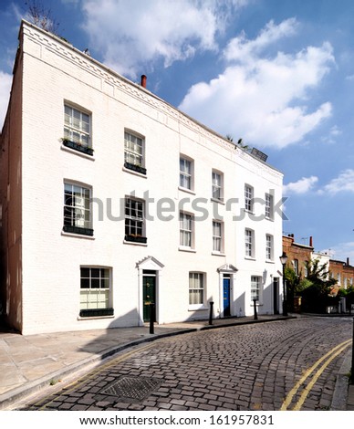 Old narrow cobbled road of 18th century Georgian period terraced houses in London, UK.