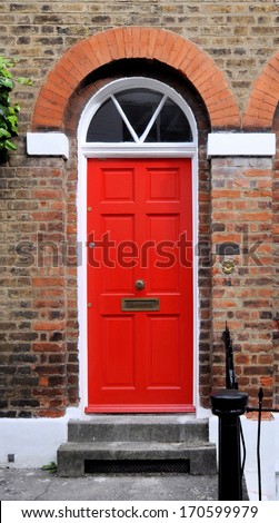 Red entrance door to 18th century Georgian London house, UK.