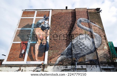 LONDON - OCOBER 11. Two huge paintings by Argentinine artist Martin Ron and Belgian artist Roa on a popular street art derelict bomb site in Hanbury Street on October 11, 2014 in east London, UK.