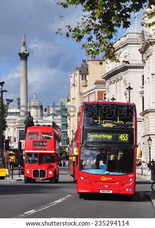 LONDON - NOVEMBER 10. Red London Transport double deck buses in Whitehall, a street of government buildings with Nelson\'s Column in the background on November 10, 2014 in central London.