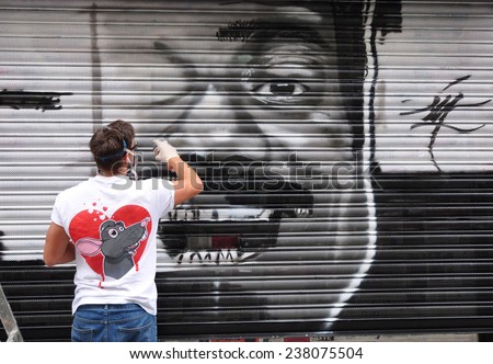 LONDON - SEPTEMBER 27. Street artist at work on shop shutter on September 27, 2014 in Hanbury Street at Shorditch in the Borouh of Tower Hamlets, east London, UK.