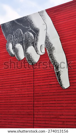 LONDON - APRIL 25, 2015. A giant pointing finger applied to \'The Shed\', the National Theatre\'s temporary red timber venue that celebrates  unexpected performances at the South Bank, London, UK.