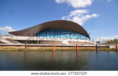 LONDON - APRIL 18. 2015. The Aquatics Centre, a public swimming facility designed by Zaha Hadid Architects with recent apartments beyond regenerating the Stratford area in east London, UK.