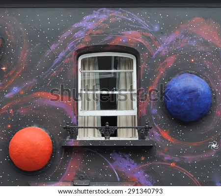 LONDON - JUNE 20, 2015. Part of a temporary painted mural with applied model planets by artist Steve Stephenson on the facade of The Chelsea Arts Club in Old Church Strret, Chelsea, London, UK.