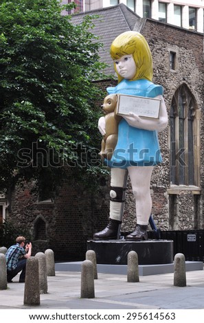 LONDON - JULY 11, 2015. Charity is a 22 feet painted bronze sculpture by Damien Hirst based on a Spastic's Society vandalised vintage collection box located at Undershaft, London, UK.
