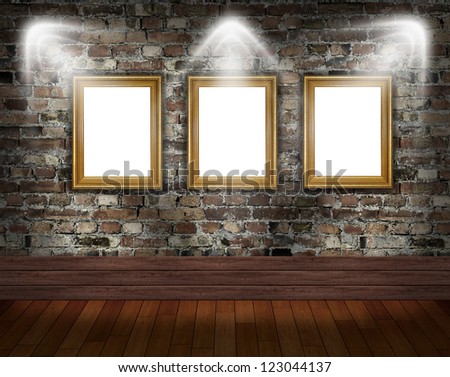 Three gold frames on brick wall in grunge room