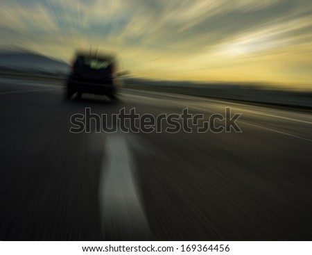 Blur car and arrow sign on road with blur sunset cloud background.