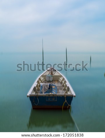 Empty fishing boat moored on the beach with motion blur background