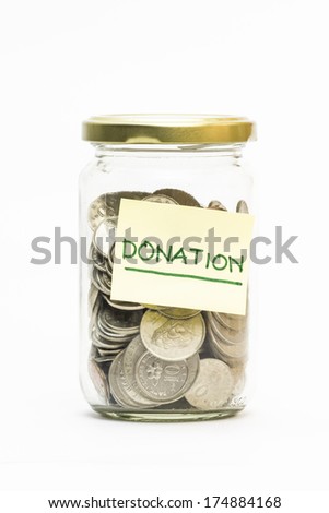 Isolated coins in jar with donation label - financial or business concept