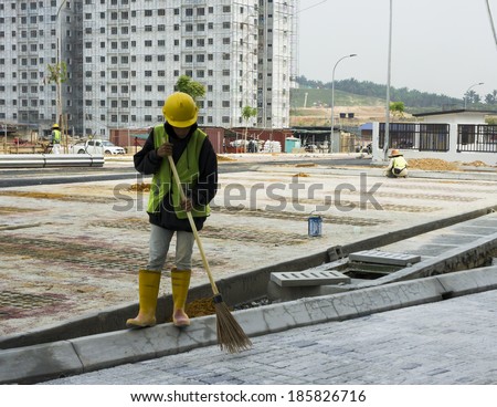 General worker sweeping debris at construction site.