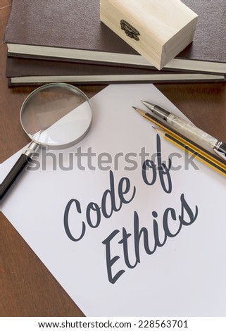Blank paper with phrase Code of Ethics on desk.