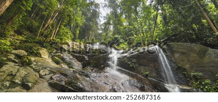 Water cascade between rocks in tropical rain forest
