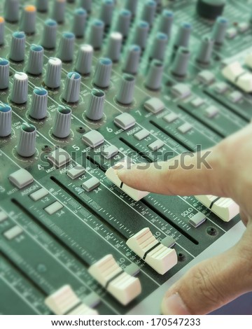 Hand of the sound producer and mixer console
