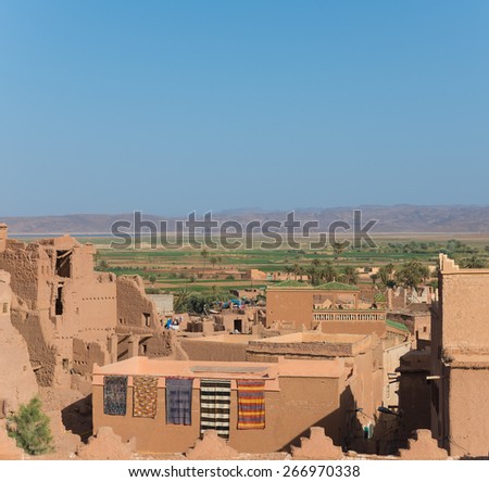 The traditional house in Arabian style with blue sky and green field in Quarzazate, Morocco