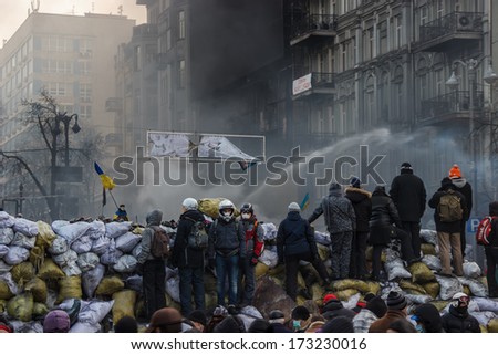 KIEV, UKRAINE - JAN 25, 2014: Confrontation on the street Hrushevskoho. Riot police extinguish burning tires from the jet. And at the same time is watering demonstrators at 14 degrees below zero