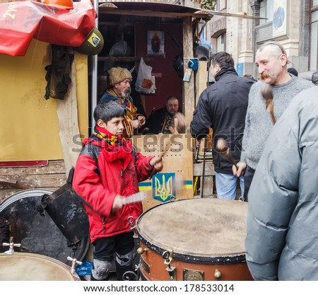 Kiev, Ukraine - on February 22, 2014: the boy in a red jacket and the man with the Cossack forelock beat the big drum on the Khreshchatyk in Kiev.