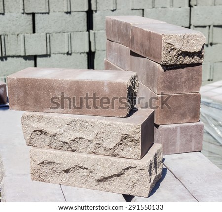 Several brown decorative bricks with some side faces, which are made in the form of rough natural stone