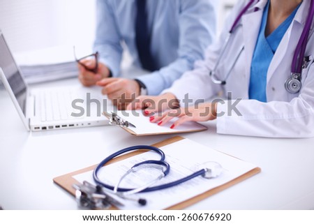 Doctor woman and patient sitting on the desk