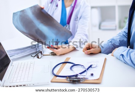 Doctor woman and patient sitting on the desk