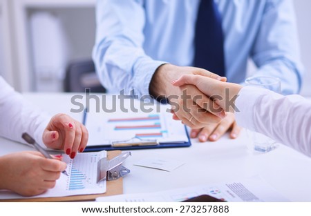 Businesspeople holding hands united over meeting table