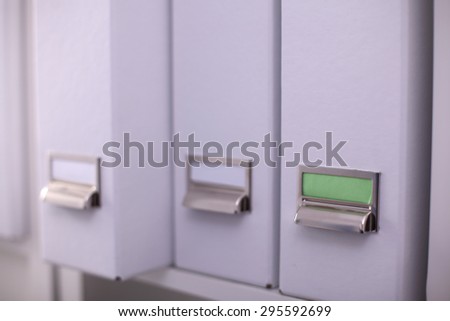 File folders, standing on  shelves in the background